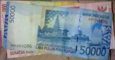 memberikan tip cara melihat hologram pada uang kertas